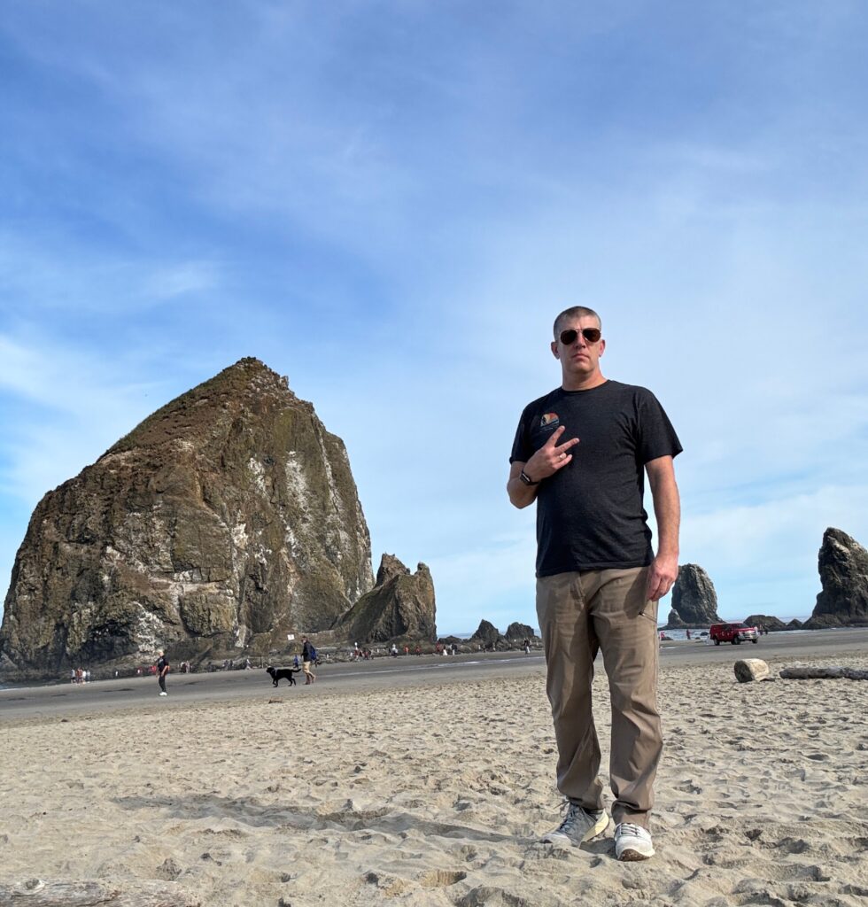 Person standing on sandy beach.