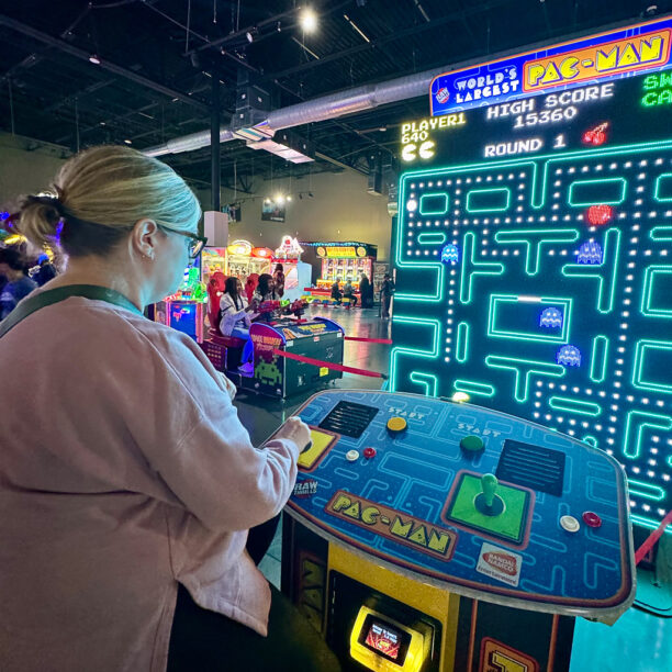 Person playing giant Pac-Man arcade game