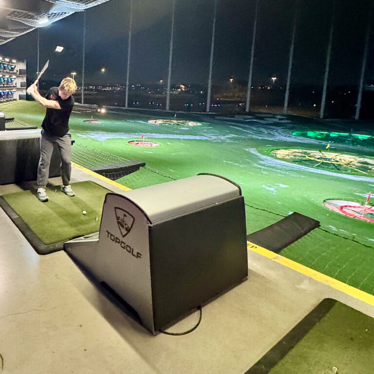 Person golfing at night indoors
